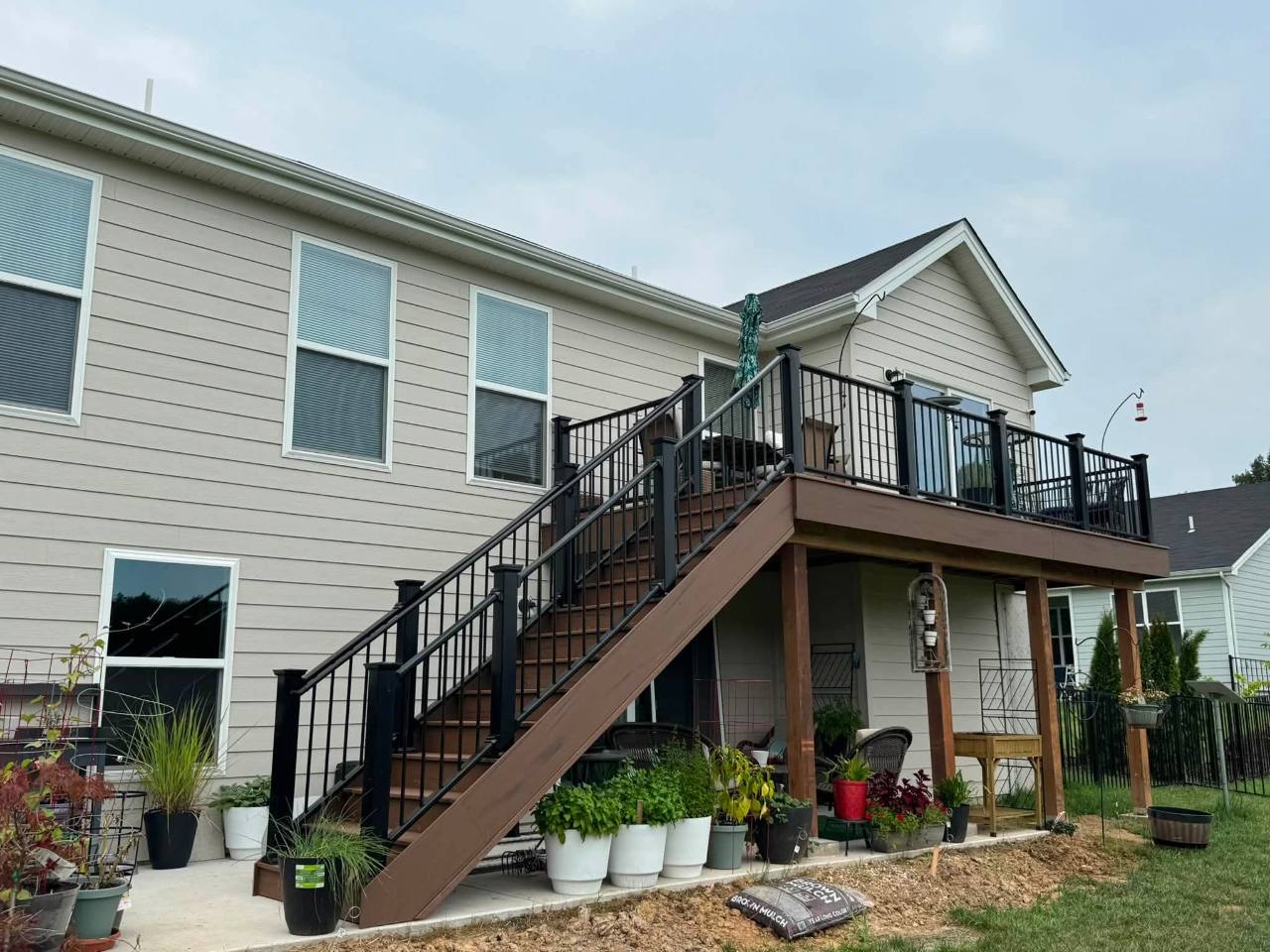 Completed TimberTech Brown Oak deck with black composite railing and aluminum spindles