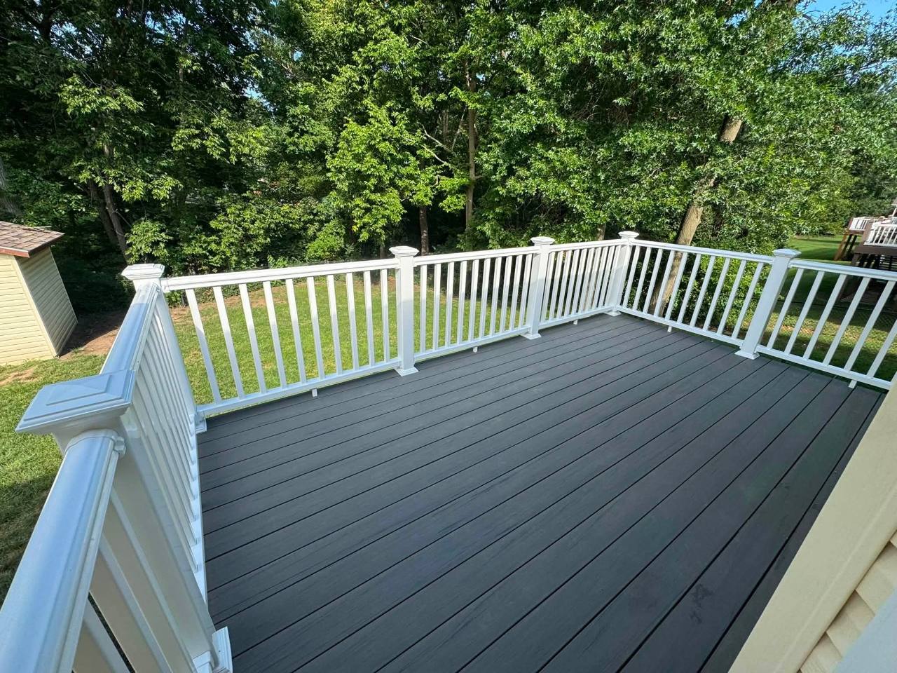 Finished gray composite elevated deck with white railing