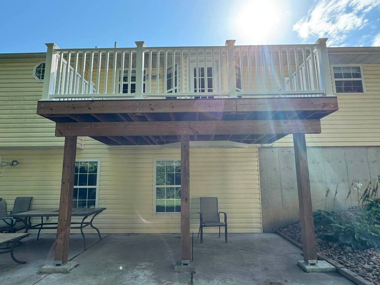 Elevated deck frame and white railing after replacement