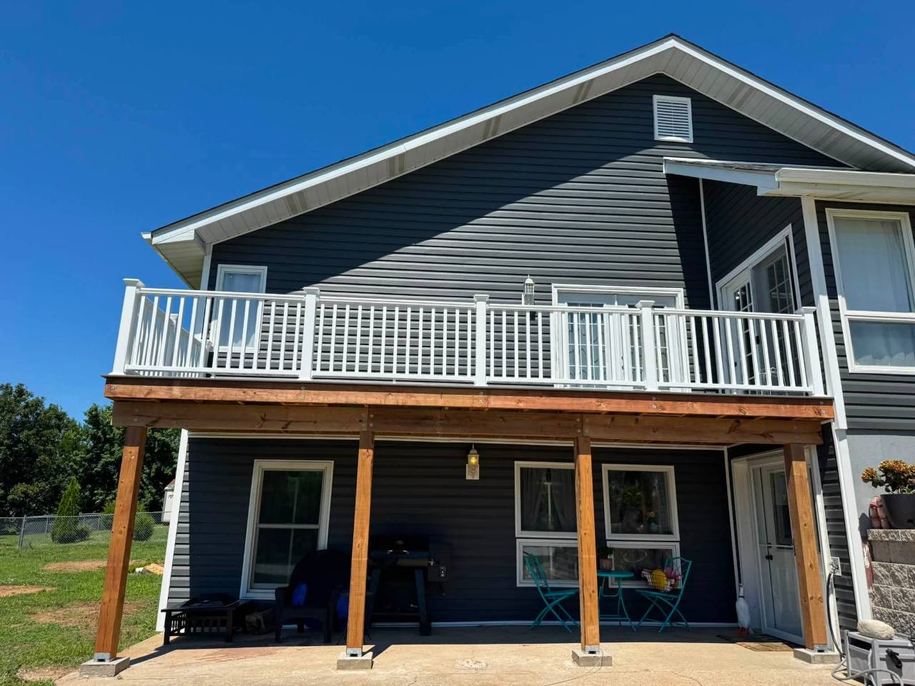 Full-width gray composite deck and white vinyl railing